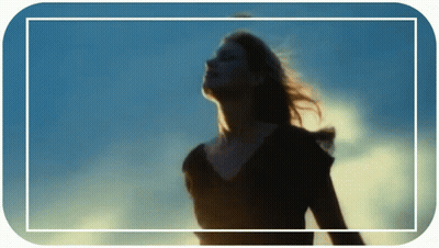 A Woman Stands In Front Of A Blue Sky GIF