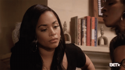 A Woman Stands In Front Of A Bookshelf With A Bet Star On The Bottom GIF
