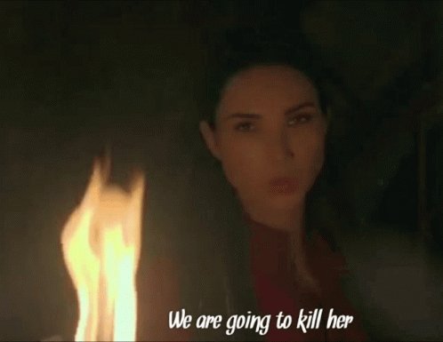 A Woman Stands In Front Of A Fire With The Words " We Are Going To Kill Her " Written Below Her GIF