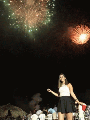 A Woman Stands In Front Of A Firework Display GIF