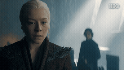 A Woman Stands In Front Of A Man In A Dark Room With Hbo Written On The Bottom GIF