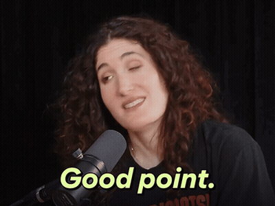 A Woman Stands In Front Of A Microphone With The Words Good Point Above Her GIF