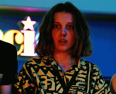 A Woman Stands In Front Of A Neon Sign That Says I GIF
