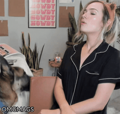 A Woman Stands In Front Of A Poster That Says Howdy On It GIF