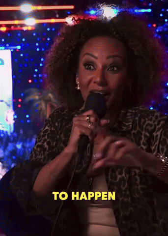 A Woman Stands In Front Of A Red Bull Sign GIF