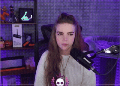 A Woman Stands In Front Of A Shure Microphone In A Purple Room GIF