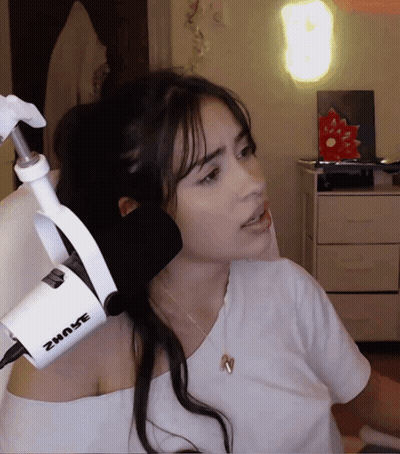 A Woman Stands In Front Of A Shure Microphone While Wearing A White Shirt GIF