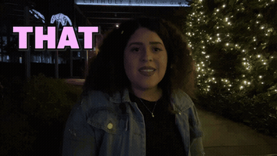 A Woman Stands In Front Of A Sign That Reads Love GIF