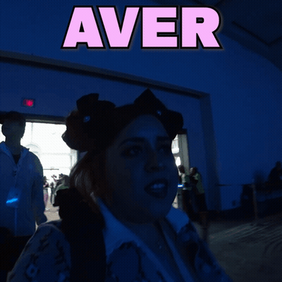 A Woman Stands In Front Of A Sign That Says " Aver " GIF