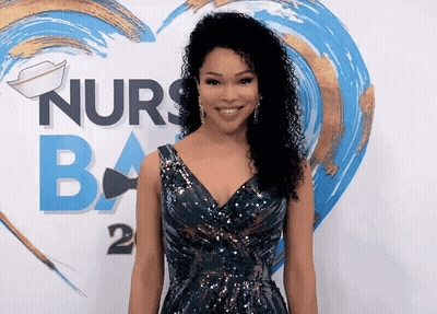 A Woman Stands In Front Of A Sign That Says Nurses Ba GIF