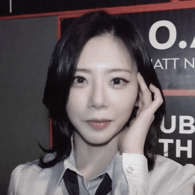 A Woman Stands In Front Of A Sign That Says O.a. Att N. GIF