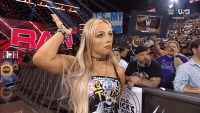 A Woman Stands In Front Of A Sign That Says Raw On It GIF