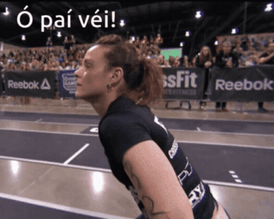A Woman Stands In Front Of A Sign That Says Reebok On It GIF