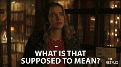 A Woman Stands In Front Of A Sign That Says What Is That Supposed To Mean Netflix GIF