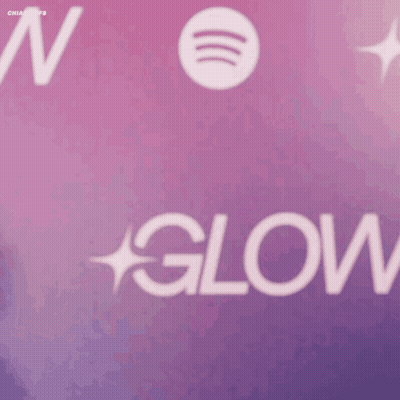 A Woman Stands In Front Of A Spotify Logo GIF