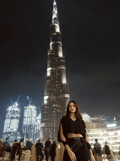 A Woman Stands In Front Of A Very Tall Building GIF