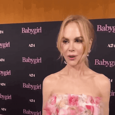 A Woman Stands In Front Of A Wall That Has Babygirl Written On It GIF