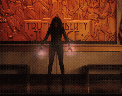 A Woman Stands In Front Of A Wall With A Sign That Says Truth Liberty Justice GIF