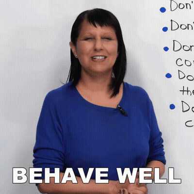 A Woman Stands In Front Of A White Board That Says Behave Well GIF