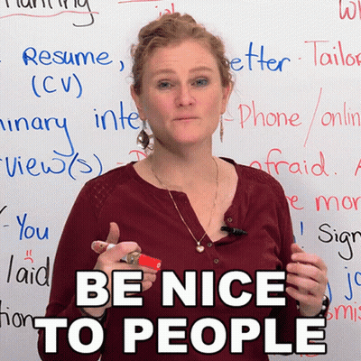 A Woman Stands In Front Of A White Board With The Words Be Nice To People On It GIF