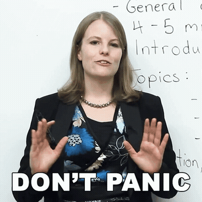 A Woman Stands In Front Of A White Board With The Words " Don 'T Panic " Written On It GIF