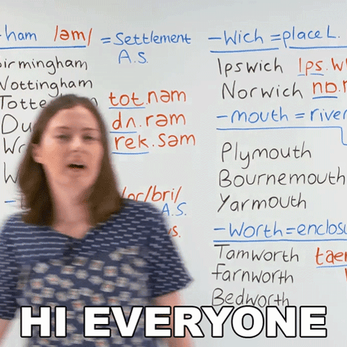 A Woman Stands In Front Of A White Board With The Words Hi Everyone Written On It GIF