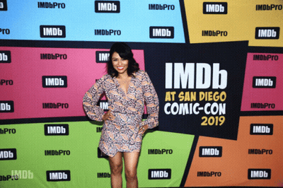 A Woman Stands In Front Of An Imdb At San Diego Comic Con 2019 Banner GIF