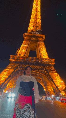 A Woman Stands In Front Of The Eiffel Tower GIF