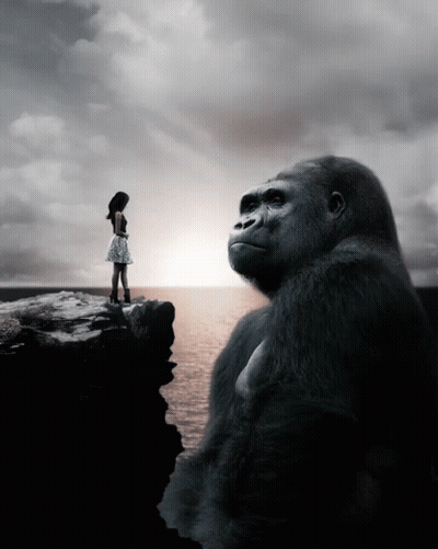 A Woman Stands On A Cliff Next To A Large Gorilla GIF