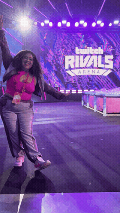 A Woman Stands On A Stage In Front Of A Twitch Rivals Arena Sign GIF