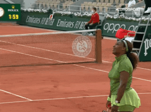 A Woman Stands On A Tennis Court In Front Of A Rolex Ad GIF