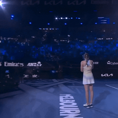 A Woman Stands On A Tennis Court In Front Of A Sign That Says ' Nba ' On It GIF