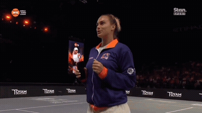 A Woman Stands On A Tennis Court In Front Of A Sign That Says ' Toyam ' GIF