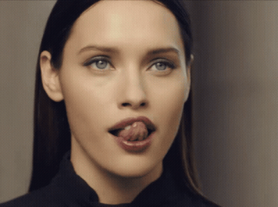 A Woman Sticking Her Tongue Out In A Close Up GIF