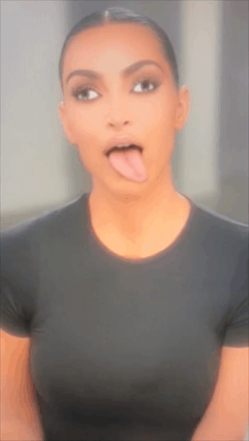 A Woman Sticking Her Tongue Out While Wearing A Black Shirt GIF