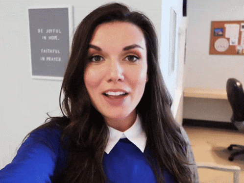 A Woman Takes A Selfie In Front Of A Sign That Says Be Joyful In Hope GIF