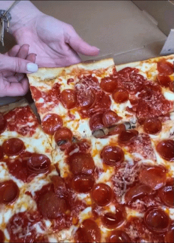 A Woman Takes A Slice Of Pepperoni Pizza Out Of A Box GIF