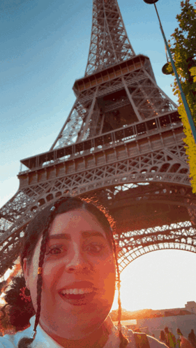 A Woman Taking A Picture In Front Of The Eiffel Tower GIF