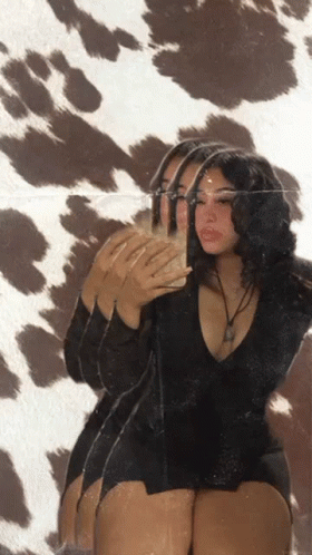 A Woman Taking A Picture Of Herself In A Mirror GIF