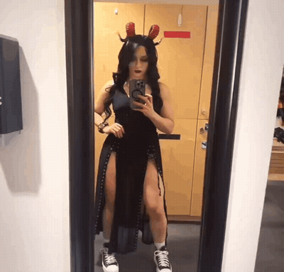 A Woman Taking A Picture Of Herself In A Mirror GIF