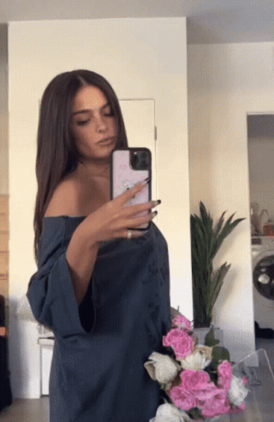 A Woman Taking A Picture Of Herself In The Mirror GIF