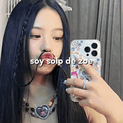A Woman Taking A Picture Of Herself With The Words Soy Solo De Zoe On The Bottom GIF