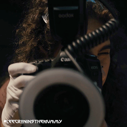 A Woman Taking A Picture With A Camera That Says Canon On It GIF
