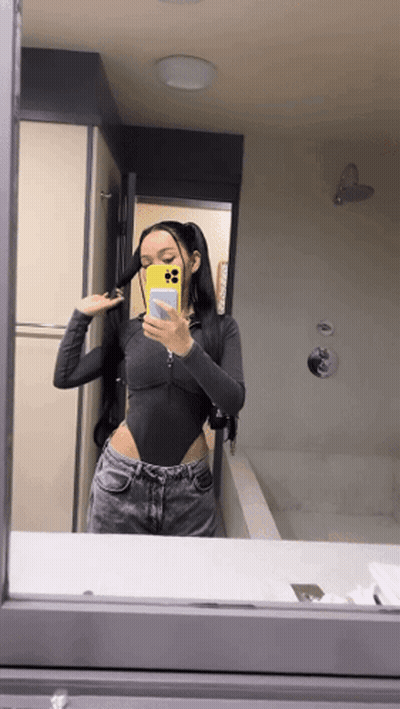 A Woman Taking A Selfie In A Bathroom Mirror GIF