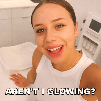 A Woman Taking A Selfie With The Words " Aren 'T I Glowing " Above Her GIF
