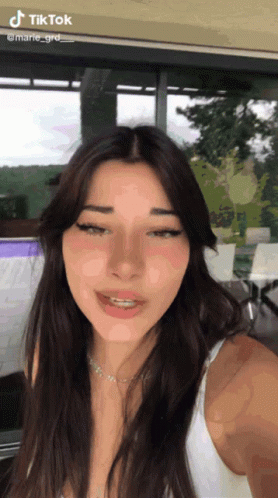 A Woman Taking A Selfie With Tiktok Written On The Bottom GIF