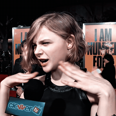 A Woman Talking Into A Microphone With A Sign That Says Clever Tv On It GIF