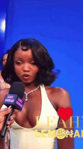 A Woman Talking Into A Microphone With Leah 'S Lemonade Written On It GIF