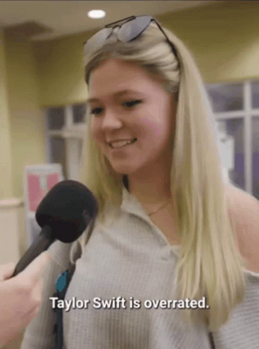 A Woman Talking Into A Microphone With The Words " Taylor Swift Is Overrated " Below Her GIF