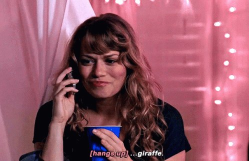 A Woman Talking On A Cell Phone While Holding A Blue Cup That Says Hang Up Giraffe GIF